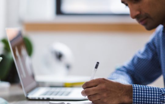 A man writing on a notepad