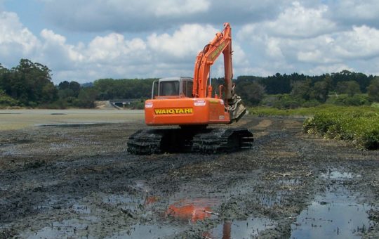 A digger on a mud flat