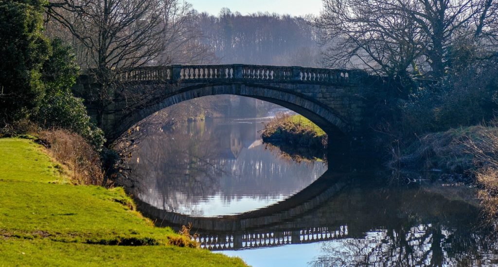 A stone bridge over a calm river